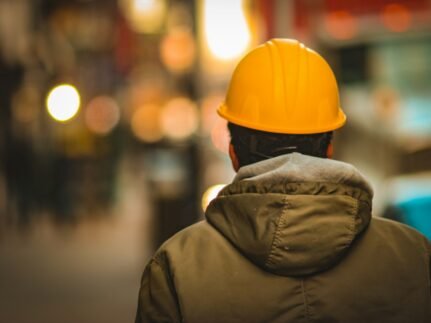 person in yellow hard hat and brown jacket